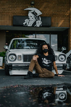 Black unisex cotton short-sleeved T-shirt with frontside scare skateboarding jack design on front in white and gray ink.