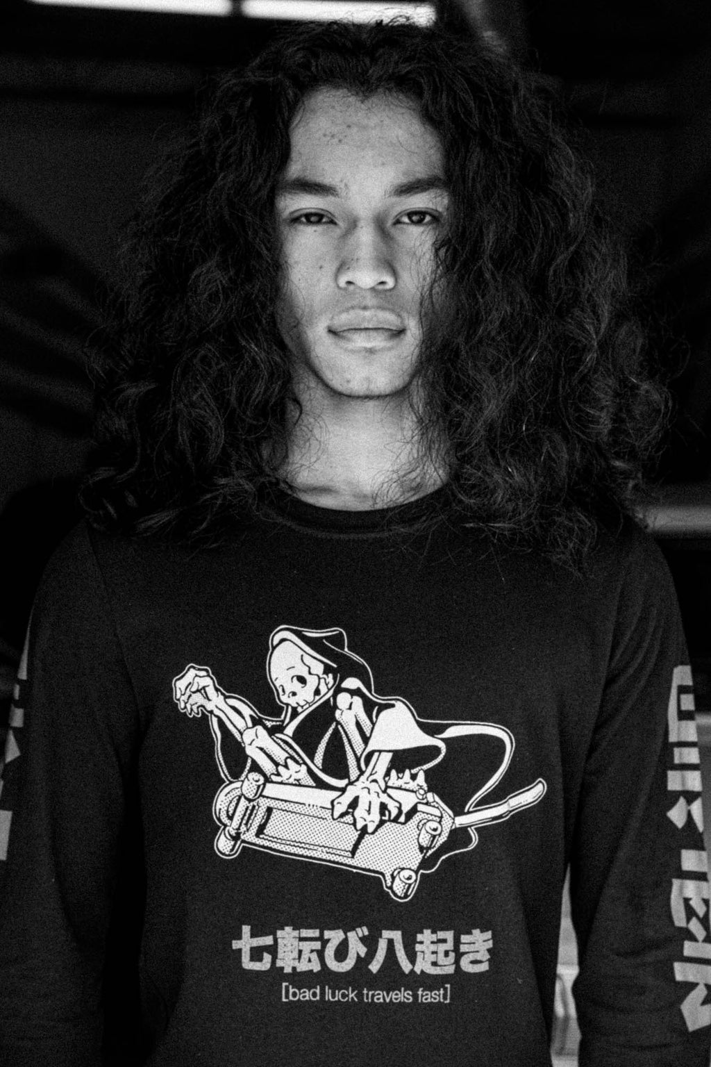 Black unisex cotton long-sleeved T-shirt with frontside scare skateboarding jack design on front in white and gray ink. Black cloud kanji in gray down the sleeves.