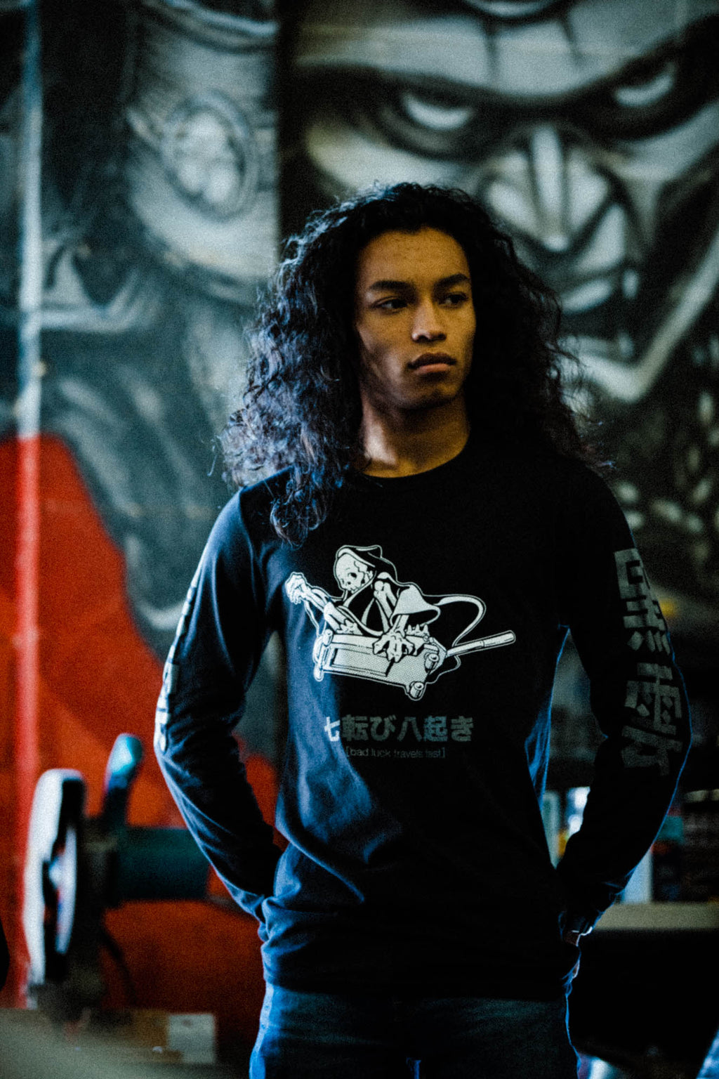 Black unisex cotton long-sleeved T-shirt with frontside scare skateboarding jack design on front in white and gray ink. Black cloud kanji in gray down the sleeves.