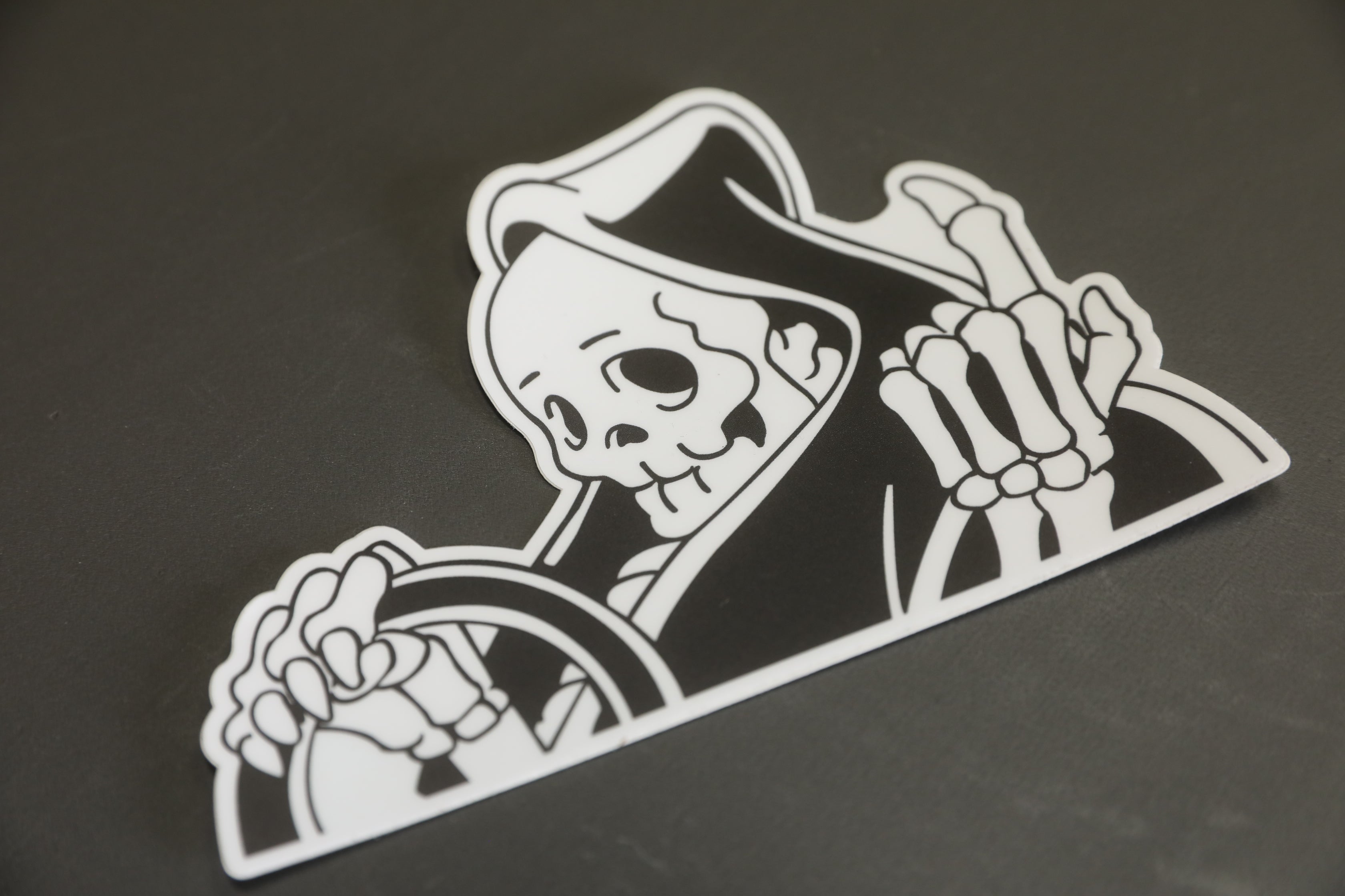 Black and white vinyl “peeker” reaper sticker. 