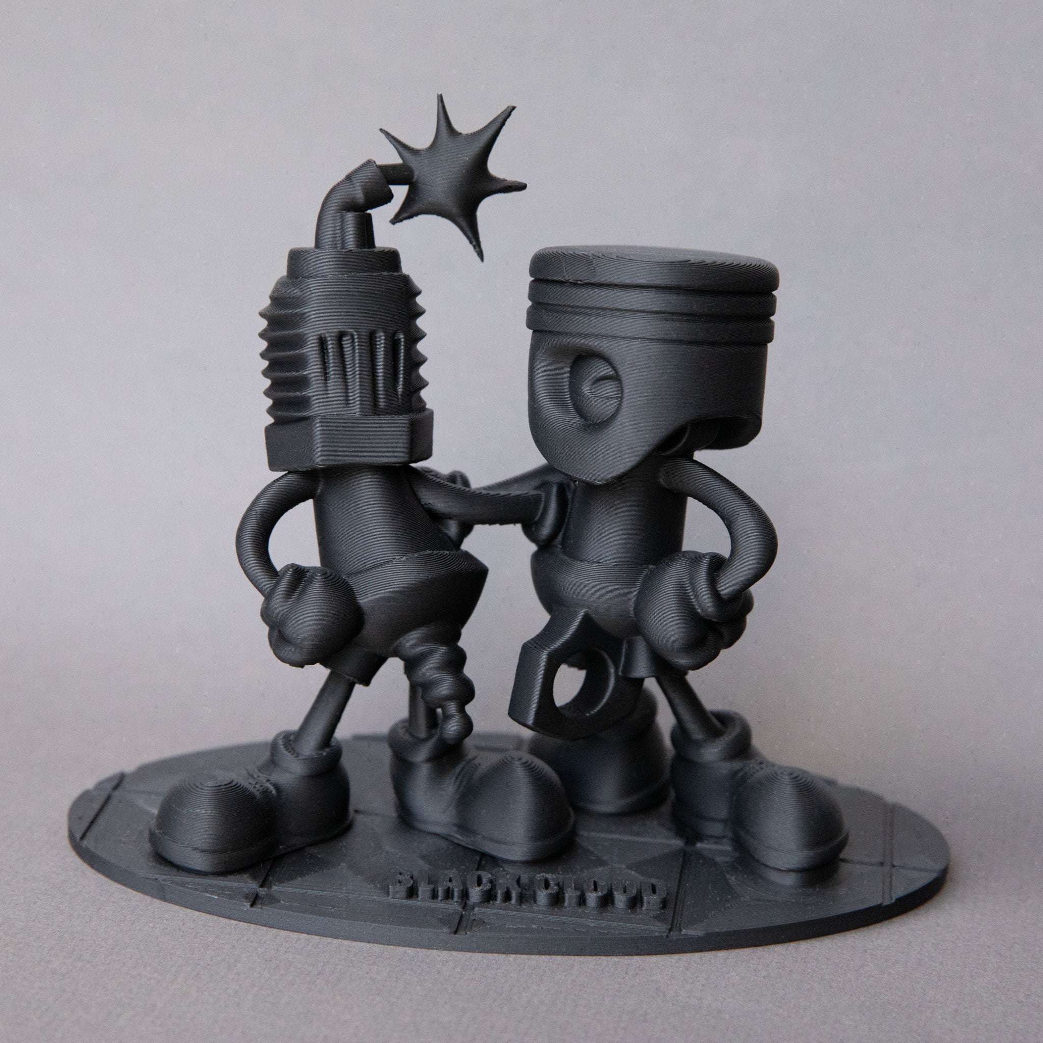 Black Cloud Chibi Piston and Spark Plug black acrylic figurine.