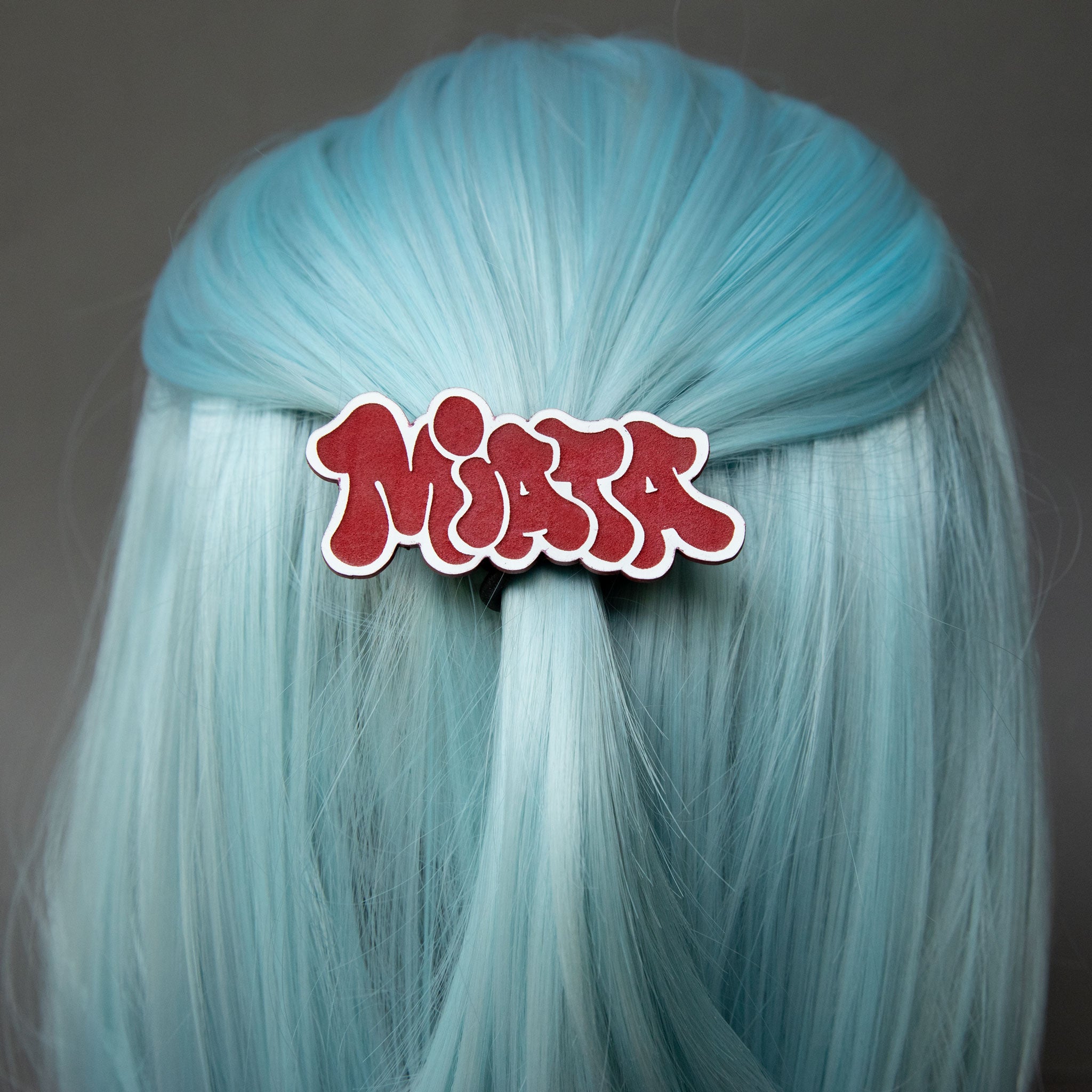 Red and white laser-engraved acrylic miata hair clip.