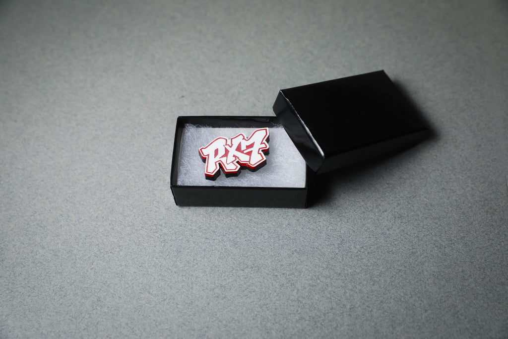 red RX7 acrylic lapel pin in jewelry box