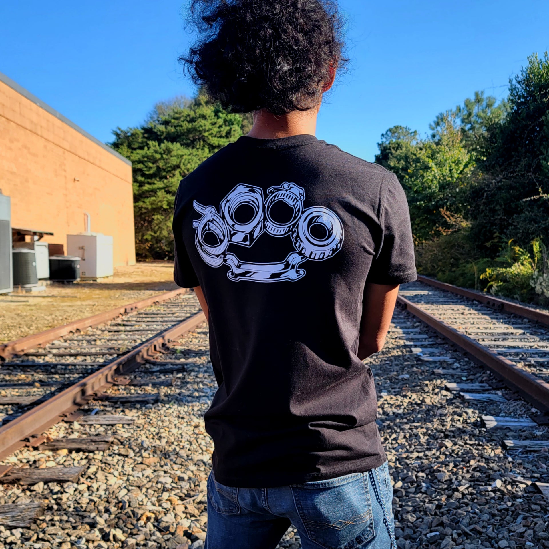 Black cotton short-sleeved T-shirt with Problem Solver brass knuckle design on back in white ink